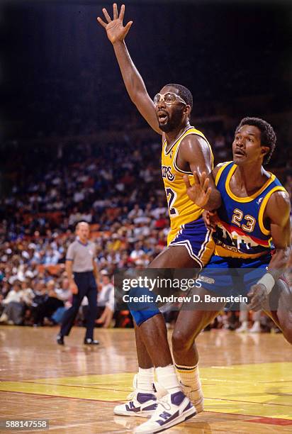 James Worthy of the Los Angeles Lakers posts up against T.R. Dunn of the Denver Nuggets during a game circa 1987 at The Forum in Los Angeles,...