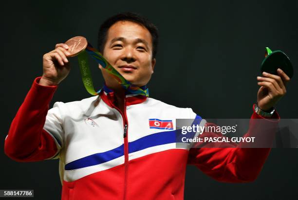 Bronze medal winner, North Korea's Kim Song Guk, celebrates on the podium during the 50m Pistol Men's Finals shooting event at the Rio 2016 Olympic...
