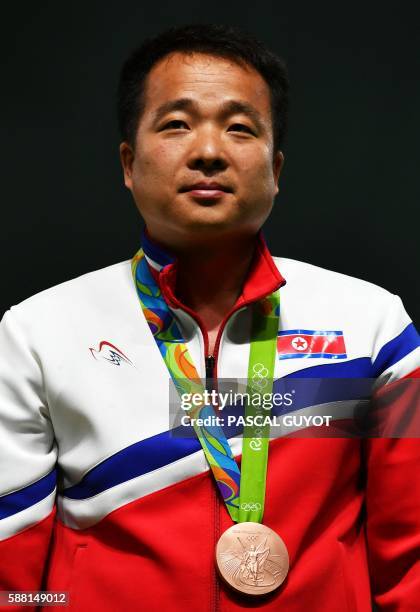 Bronze medal winner, North Korea's Kim Song Guk, stands on the podium during the 50m Pistol Men's Finals shooting event at the Rio 2016 Olympic Games...