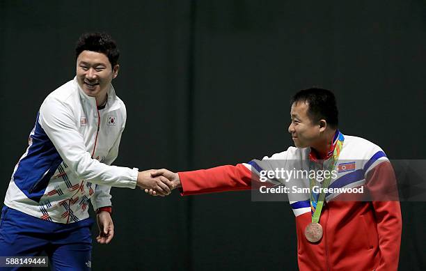 Gold medalist Jongoh Jin of Korea shakes hands with bronze medalist Song Guk Kim following the 50m pistol event on Day 5 of the Rio 2016 Olympic...
