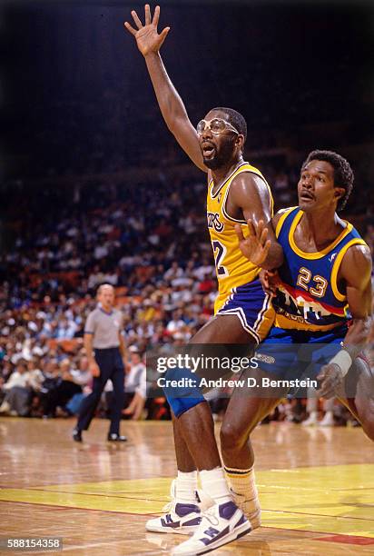 James Worthy of the Los Angeles Lakers posts up against T.R. Dunn of the Denver Nuggets during a game circa 1987 at The Forum in Los Angeles,...