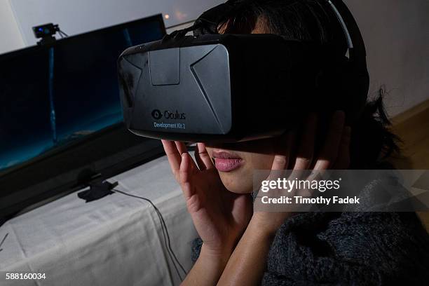 Woman wears a virtual reality headset / goggles / visor made by Oculus Rift, and experiences a virtual reality tour of the Salvador Dali Museum....