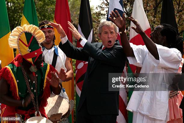 President George Bush and First Lady Laura Bush dance with the Kankouran West African Dance Company on Malaria Awareness Day, in Rose Garden of the...