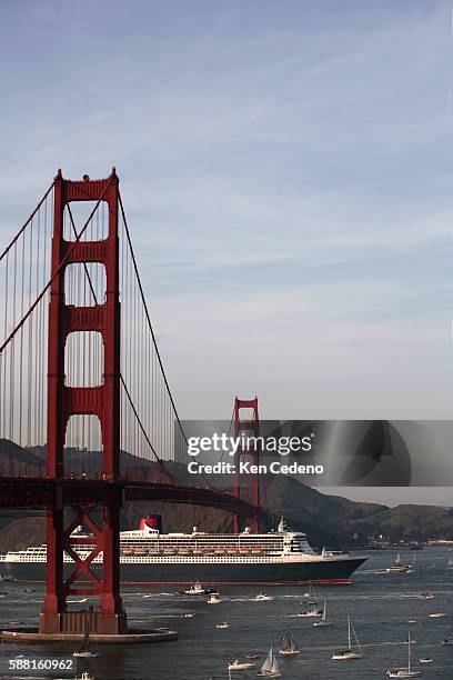 The Queen Mary 2 passes under the Golden Gate Bridge in San Francisco, while surrounded by hundreds of smaller boats and vessels. The famous luxury...