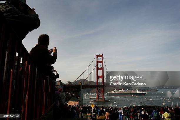 Spectators watch as the Queen Mary 2 prepares to pass under the Golden Gate Bridge in San Francisco, while surrounded by hundreds of smaller boats...