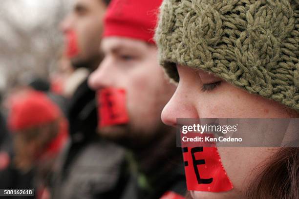 Anti-abortion supporters wear red tape across their mouths during the Annual march for Life rally, in front of U.S. Supreme Court in Washington DC....