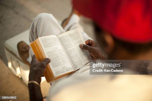 Pastor Ernest Dison of St. Paul Church of God in Christ reads his bible during a tent revival in the lower 9th ward of New Orleans July 15, 2010....
