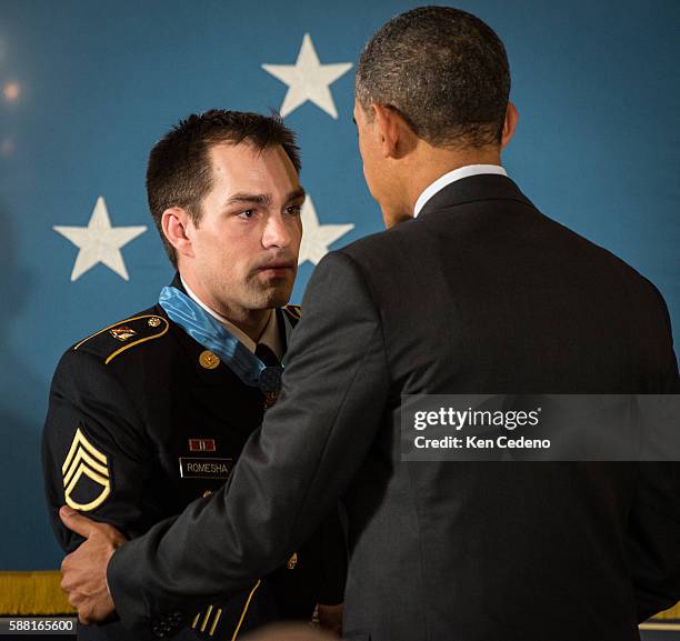 President Barack Obama shales hands with Clinton Romesha, a former active duty Army Staff Sergeant, after awarding him the Medal of Honor for...