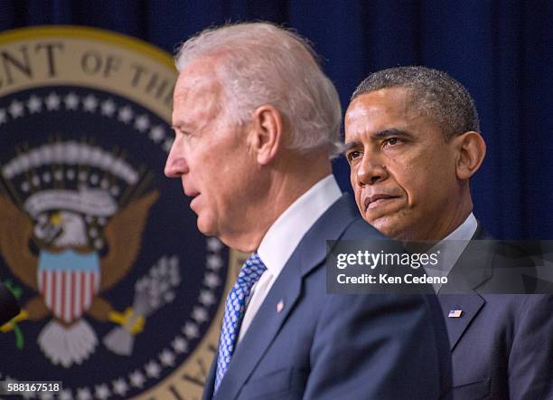 President Barak Obama listens on as and Vice President Joe Biden speaks about the administration's new gun law proposals to reduce gun violence...