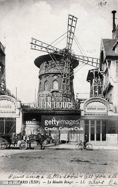 Paris scene. 13th arrondisement. Le Moulin Rouge famous for its cabaret shows. Horse and carriage drawn up outside.
