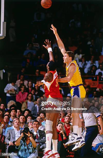 Mike Smrek of the Los Angeles Lakers shoots the ball against Tree Rollins of the Atlanta Hawks during a game circa 1988 at The Forum in Los Angeles,...