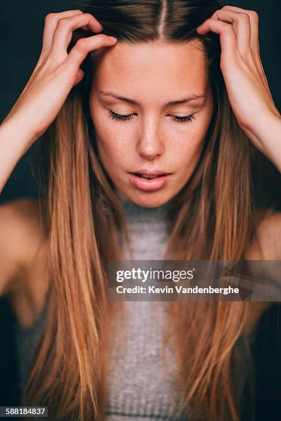 beautiful girl rubbing her hair looking down - hairline polished metal bildbanksfoton och bilder