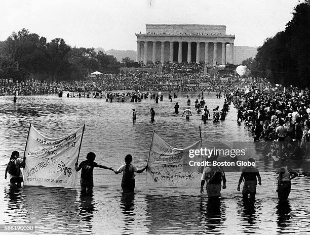 Participants in the March on Washington stand in the reflecting pool in front of the Lincoln Memorial in Washington DC on Aug. 27 to observe the 20th...