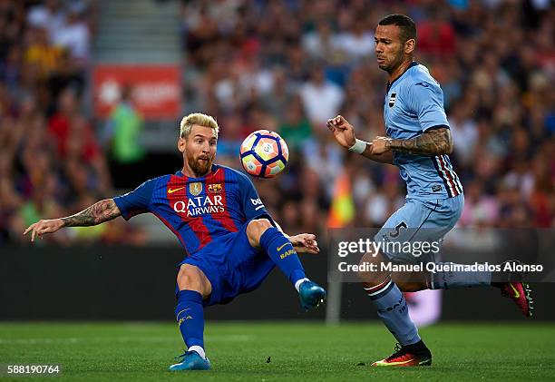 Lionel Messi of FC Barcelona controls the ball ball behind Leandro Castan of Sampdoria during the Joan Gamper trophy match between FC Barcelona and...