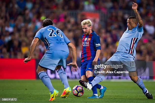 Lionel Messi of FC Barcelona conducts the ball between Matias Agustin Silvestre and Angelo Palombo of UC Sampdoria during the Joan Gamper trophy...