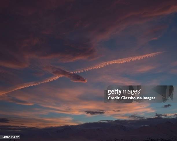 pink clouds above mountains with jetstream, alaska, usa - jetstream stock-fotos und bilder