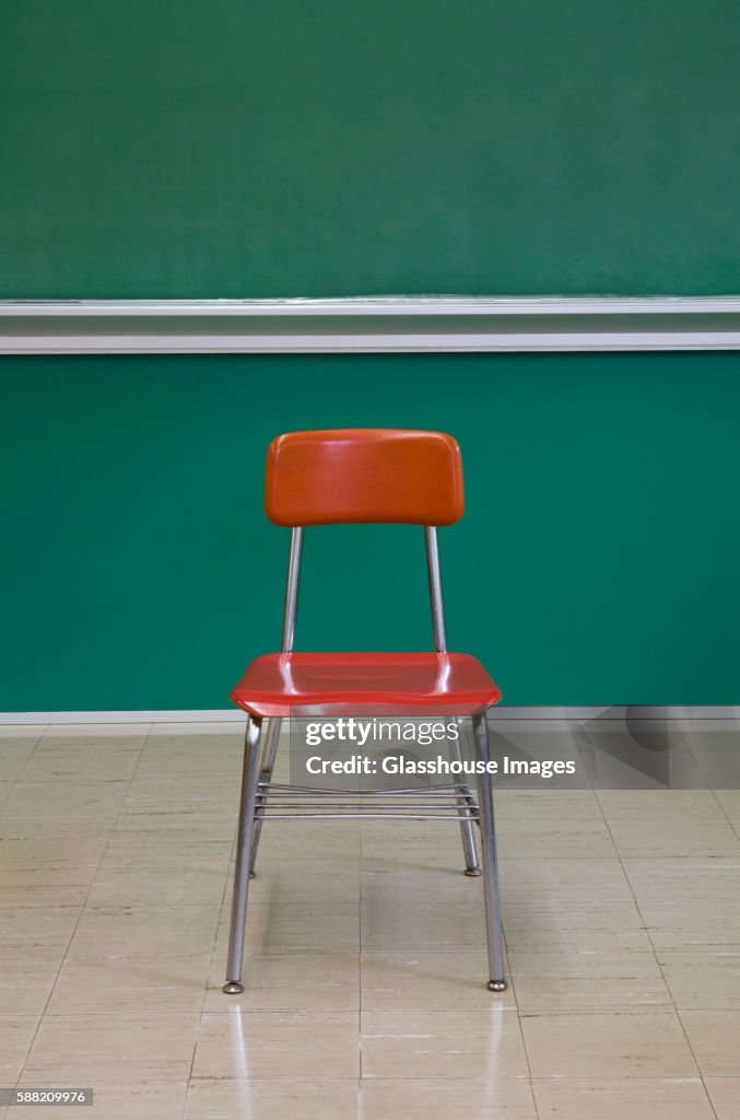 Empty Red Chair by Chalkboard