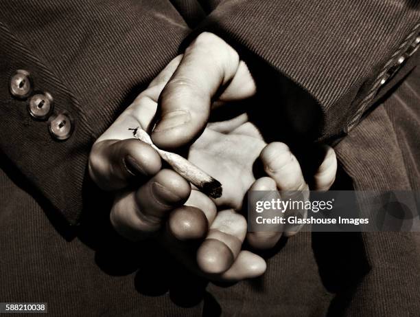 hands holding cigarette - human joint stock-fotos und bilder