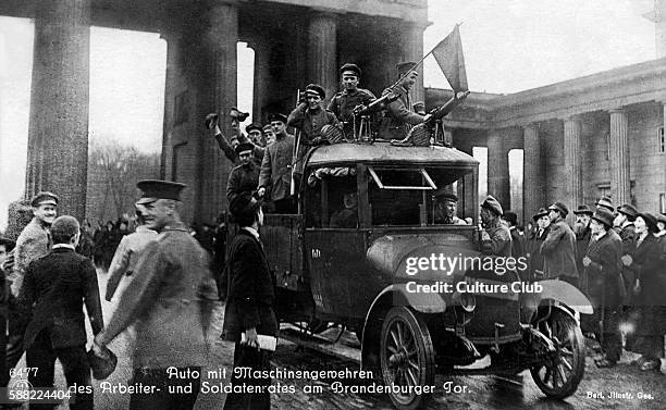 German Revolution in Berlin, Germany, 1918. Car with machine guns in front of the Brandenburger Tor with council of workers and soldiers. In November...