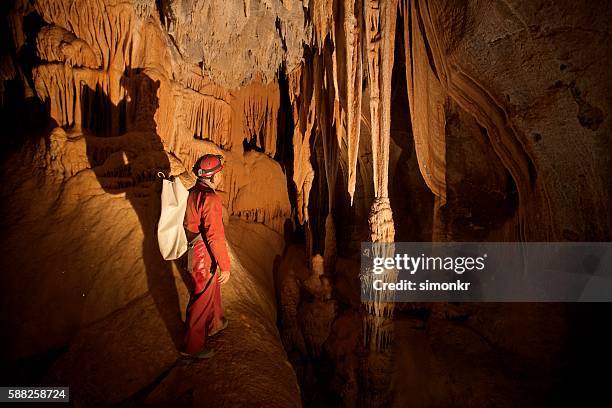 caver exploring stalactites - 洞窟 個照片及圖片檔