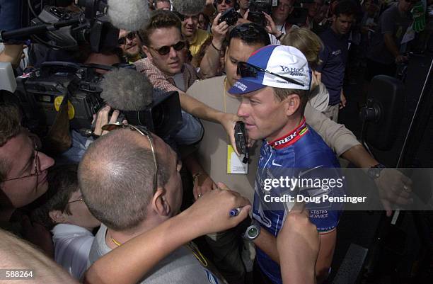 Lance Armstrong of the USA and riding for the US Postal Service Team is the center of attention as he exits the team bus prior to Stage 2 of the 2001...