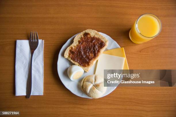 toast with jam, hardboiled egg, roll, cheese and orange juice for breakfast - cheese jam stock-fotos und bilder