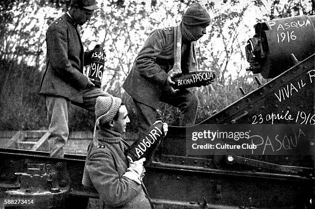 Italian artillery gunners at Easter 1916. Munition shells have East messages written on them . Guns stationed in the Italian Alps intended for...