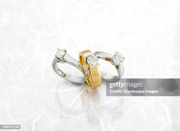 three engagement rings on reflective surface - gemstone ring stock pictures, royalty-free photos & images