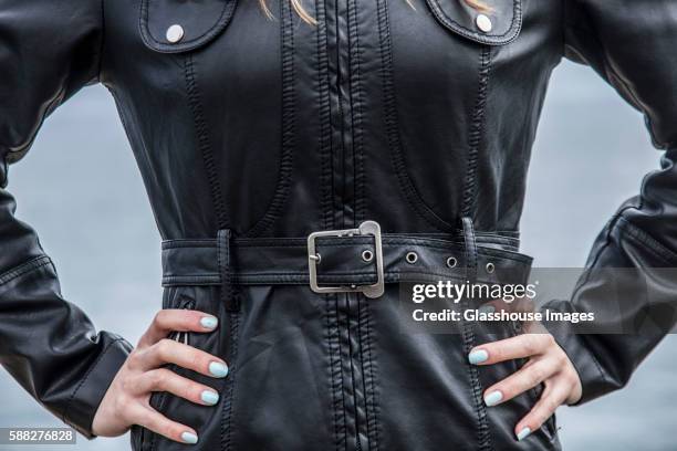 torso of woman wearing black leather jacket - ベルト ストックフォトと画像