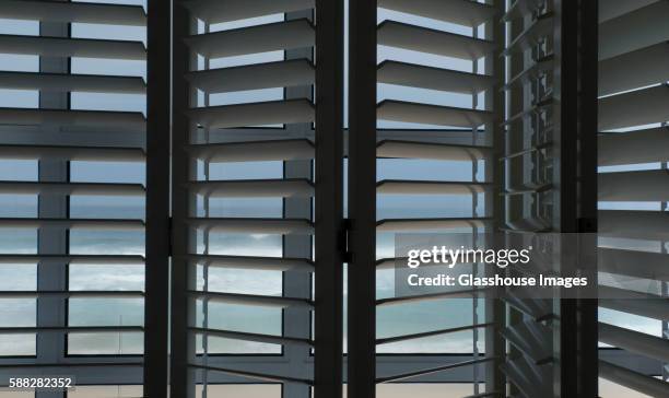 window shutters with view of ocean, plettenburg bay, south africa - jalousie stock-fotos und bilder