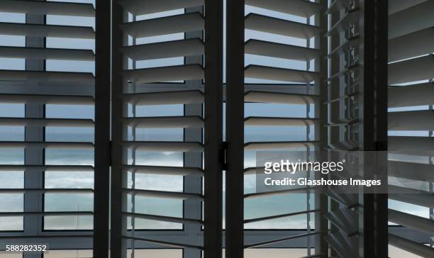 window shutters with view of ocean, plettenburg bay, south africa - tapparelle foto e immagini stock