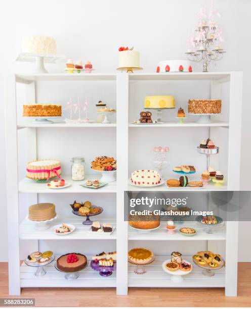 assorted desserts on white shelves - cake tier stock pictures, royalty-free photos & images