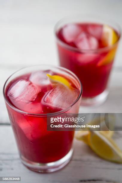 two glasses of cranberry juice with ice and lemon - cranberry juice stock pictures, royalty-free photos & images