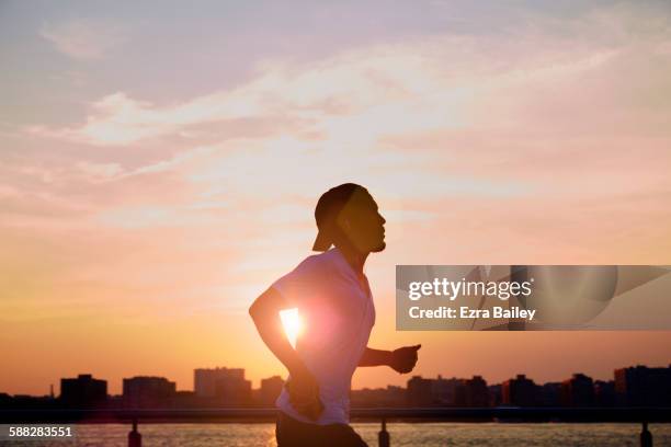 man enjoying an early morning jog in the city. - morning imagens e fotografias de stock