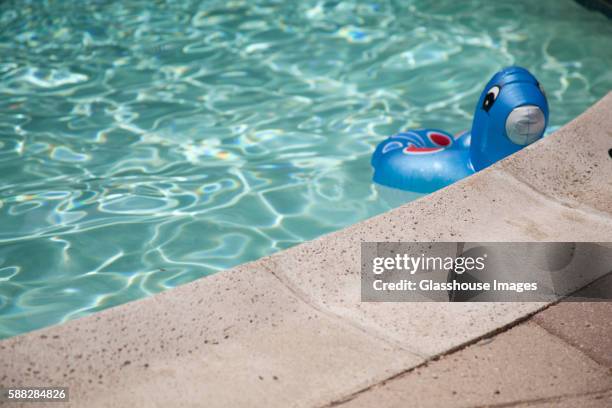 float toy in swimming pool - en el borde fotografías e imágenes de stock
