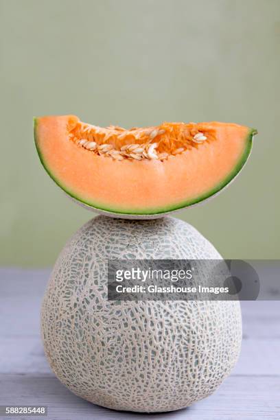 cantaloupe slice on top of whole cantaloupe - muskmelon stock pictures, royalty-free photos & images