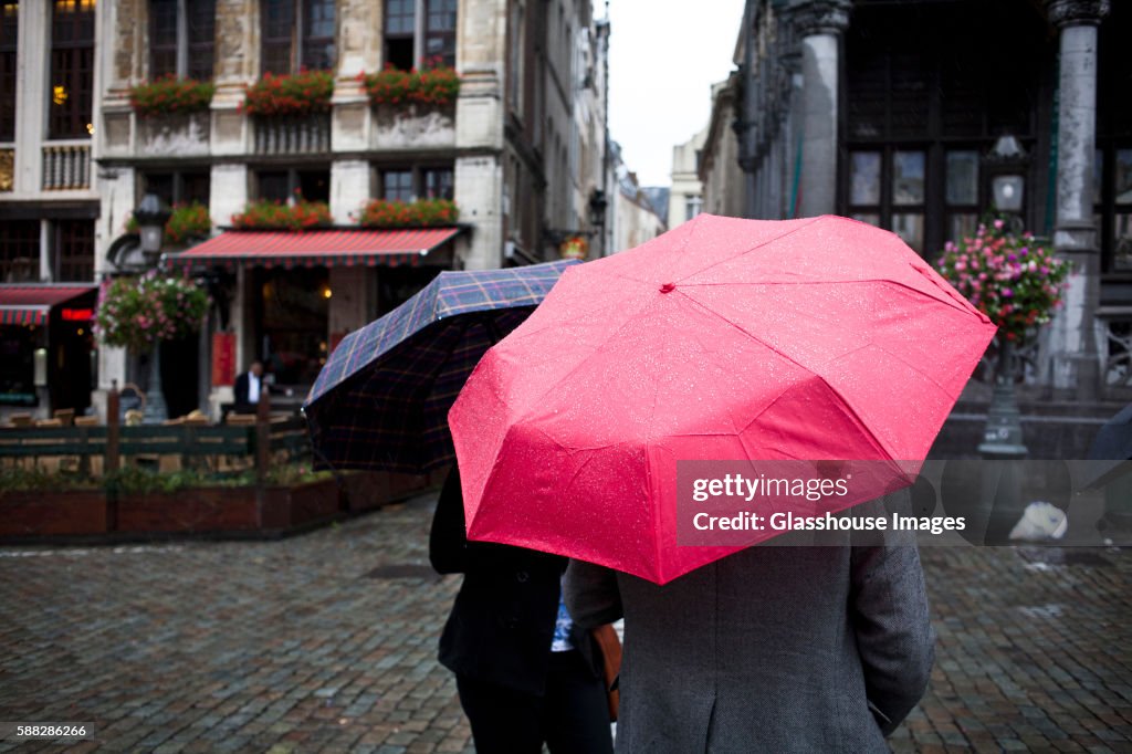 Two People Holding Umbrellas in Rain, Brussels, Belgium