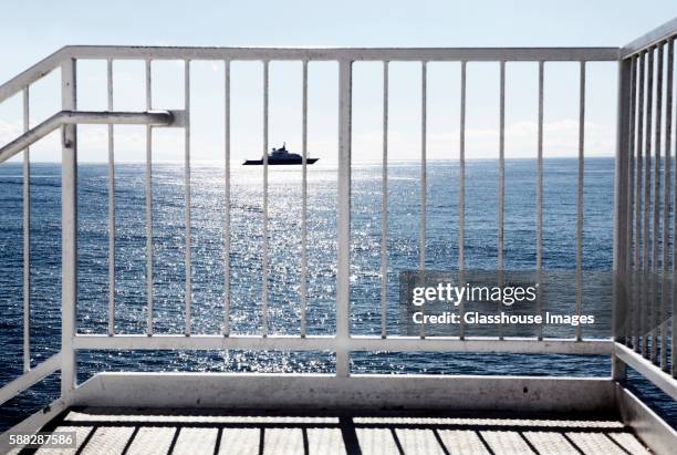 view of yacht through metal railing, malibu, california, usa - geländer stock-fotos und bilder