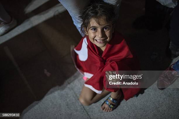 Child girl covered with a Turkish flag is seen as people gather at the Presidential Complex to protest July 15 failed military coup attempt in...