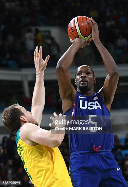 Australia's guard Patty Mills jumps to score past Australia's small forward Joe Ingles during a Men's round Group A basketball match between...
