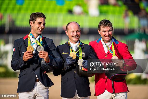 Michael Jung of Germany, Astier Nicolas of France and Phillip Dutton of the United States celebrate at the awarding ceremony of the equestrian...