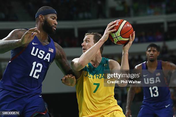 Joe Ingles of Australia handles the bal against Demarcus Cousins of United States as Paul George looks on during the Men's Preliminary Round Group A...