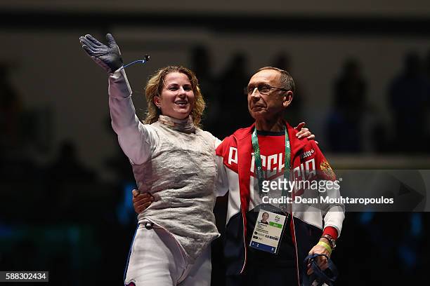 Inna Deriglazova of Russia and her coach celebrate victory over Elisa di Francisca of Italy following the women's individual foil gold medal bout on...