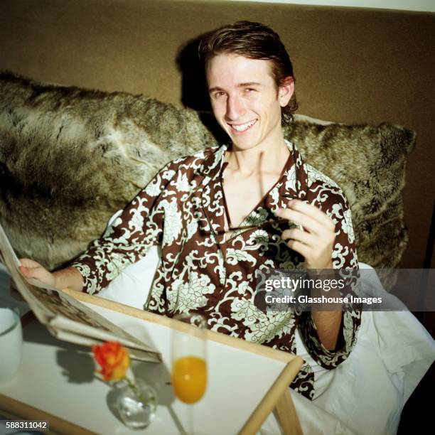 young adult man having breakfast in bed - read and newspaper and bed stock pictures, royalty-free photos & images