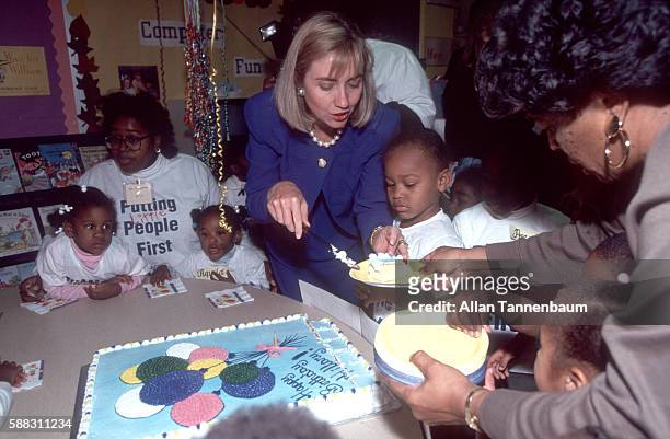 On her birthday, American lawyer Hillary Clinton serves cake to children at a dacare center during a Presidential campaign stop on behalf of her...