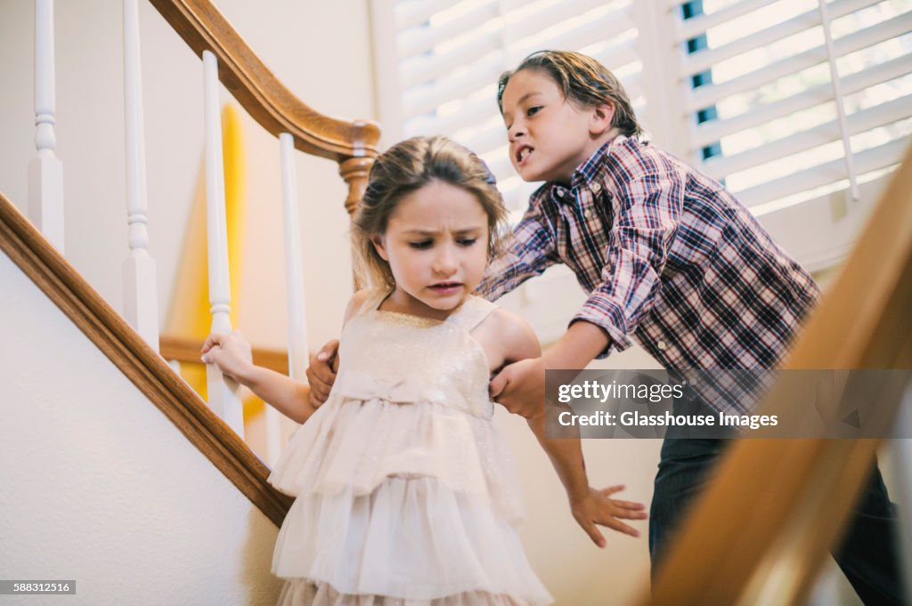 Boy Grabbing Girl's Arm on Stairs