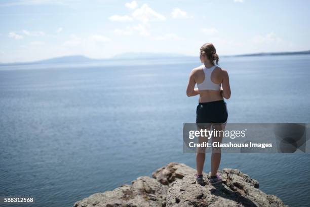 teenage girl jogger staring out over lake - woman running shorts stock pictures, royalty-free photos & images