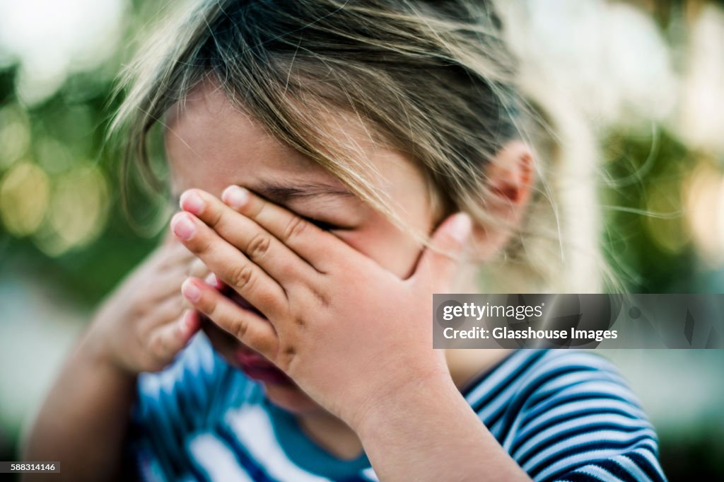 Young Girl Crying with Hands Covering Face