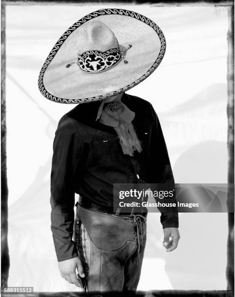 mexican cowboy with large brim hat looking down - western shirt stockfoto's en -beelden