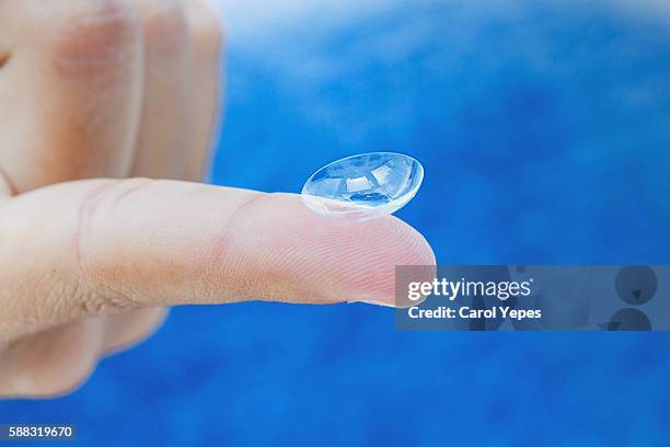 close-up of contact lens on womans finger - lente de contacto imagens e fotografias de stock